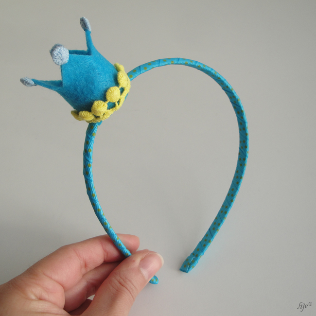 Aro de cabelo azul com coroa decorativa azul e amarelo