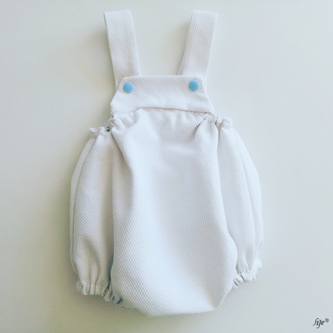 Macacão branco para bebé com botões azuis e tecido texturizado