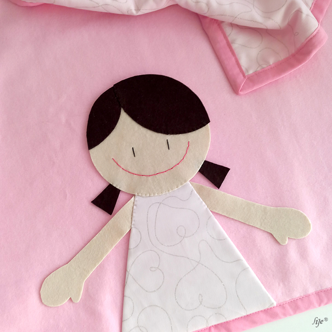 Pano de bebé cor-de-rosa com aplicação de menina sorridente em tecido