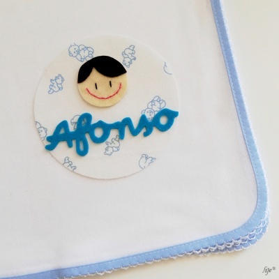 Fralda branca com borda azul claro e decoração com nome Afonso