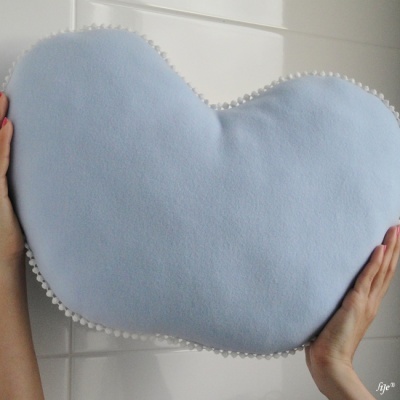 Almofada azul claro com borda de pompons brancos