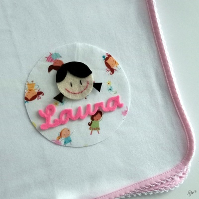 Fralda branca com borda rosa e aplicação circular com nome Laura