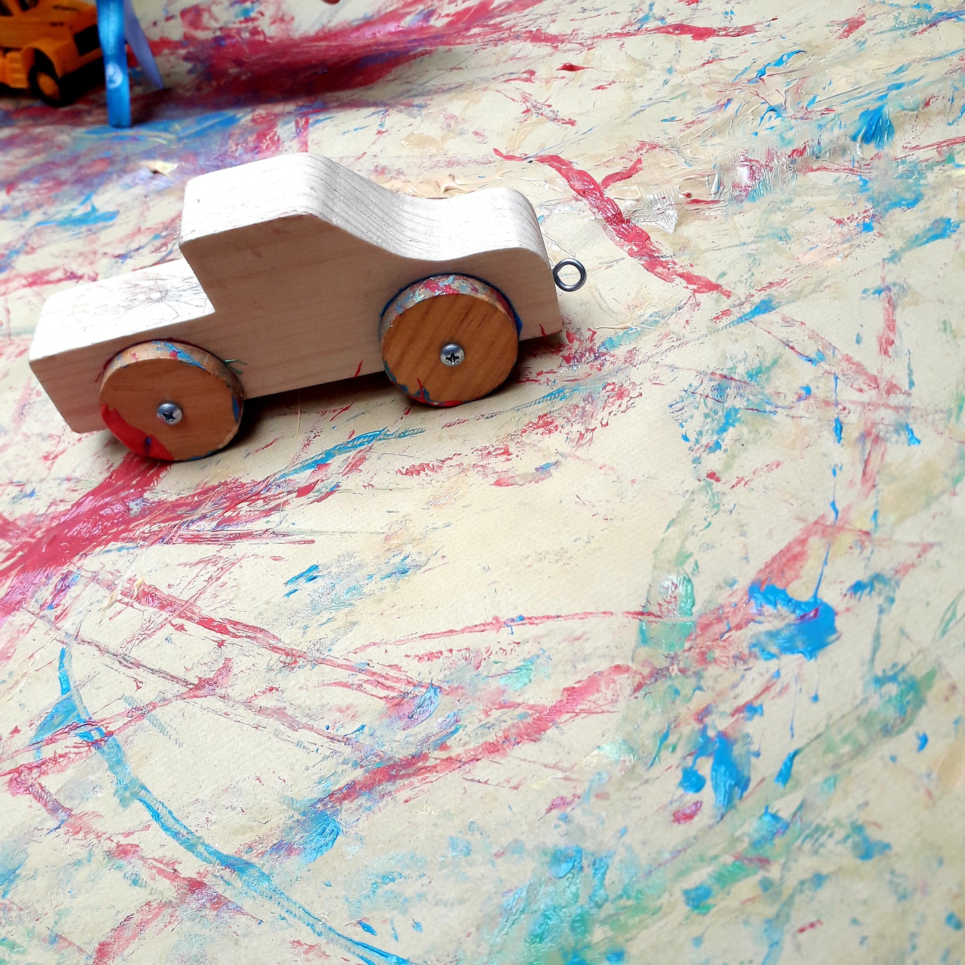 Carrinho de madeira com rodas de madeira em superfície colorida