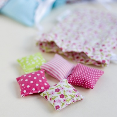 Pequenas almofadas de tecido com padrões florais e de bolinhas coloridas