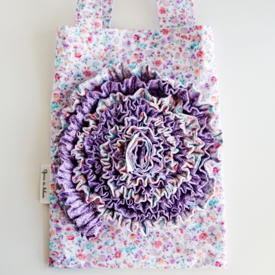 Bolsa de tecido floral branca com adorno roxo frisado