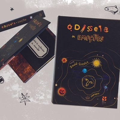 Livro e caixa pretos com ilustrações coloridas de corpos celestes e texto em português