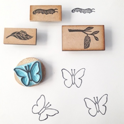 Carimbos de madeira com desenhos de lagarta, casulo, folha e borboleta