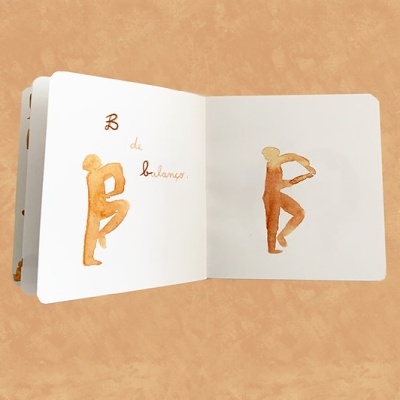 Livro aberto com ilustrações de figuras humanas em equilíbrio e texto 'B de balanço'