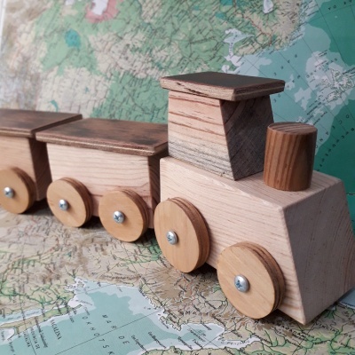 Brinquedo de trem de madeira sobre mapa colorido