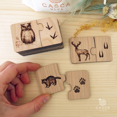 Peças de puzzle em madeira com desenhos de animais e pegadas
