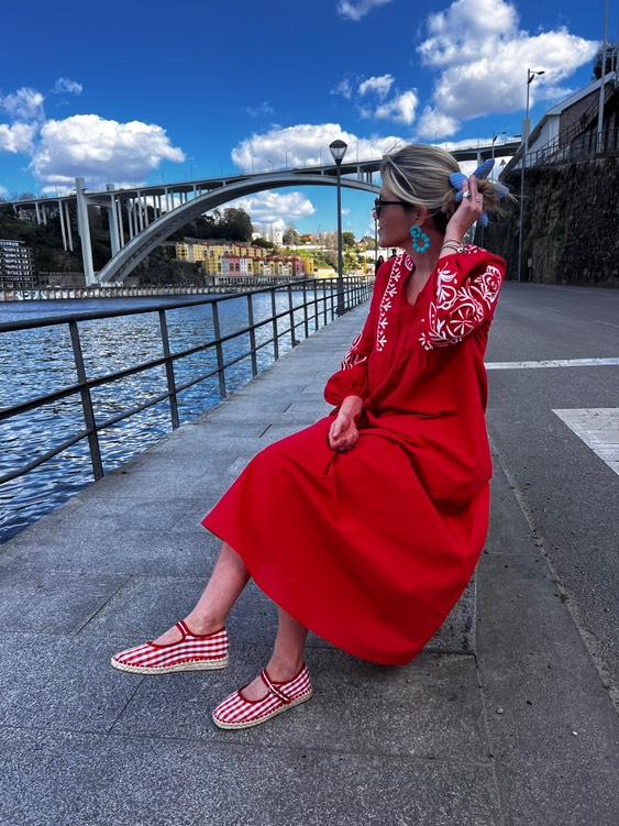 Mary Jane Vichy Vermelho e Branco Mulher sentada à beira do rio com vestido vermelho estampado e sapatos xadrez