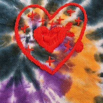 Tecido tie-dye com bordado de coração e estrelas coloridas