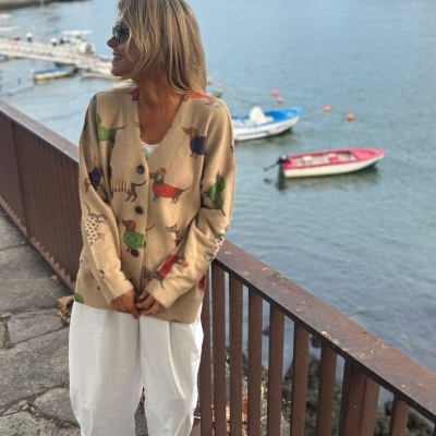 Cardigã bege com padrão de cães coloridos junto a rio e ponte