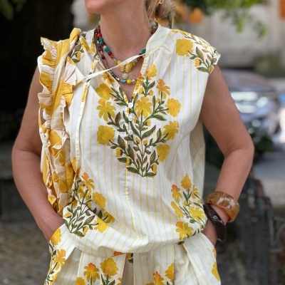 Conjunto feminino com padrão floral amarelo e verde, blusa com folhos, outdoors urbano