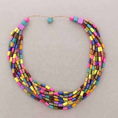 Colar colorido com múltiplas fileiras de contas retangulares em várias cores sobre fundo cinza claro