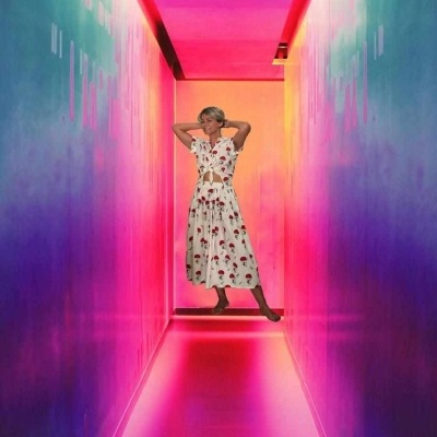 Mulher com vestido floral branco num corredor iluminado com luzes coloridas