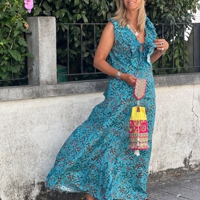 Mulher a usar vestido longo azul floral com folhos e acessórios em ambiente urbano