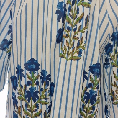 Blusa listrada azul e branca com flores azuis e folhas verdes exibida numa manequim