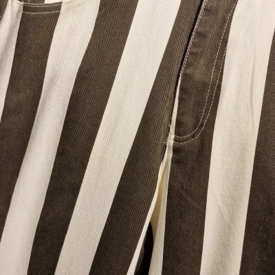 Calças com riscas verticais castanhas e creme com botão metálico prateado