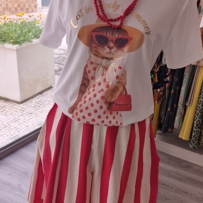 Manequim com t-shirt branca com desenho de gato e calças largas riscas vermelhas e brancas