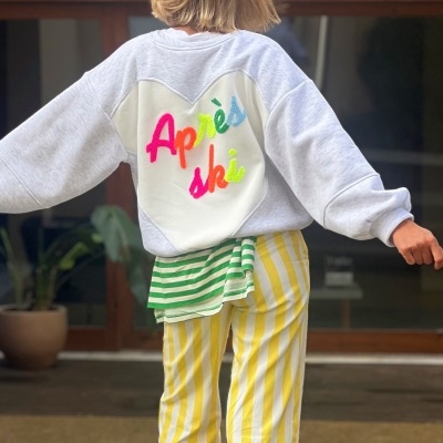 Camisola branca com painel em forma de coração e texto colorido blonde jogando braços para os lados