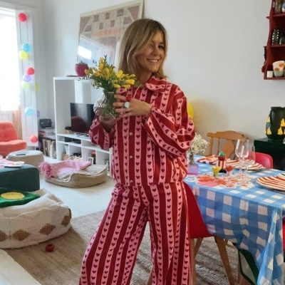 Macacão com riscas verticais e corações em vermelho e rosa usado por mulher dentro de casa