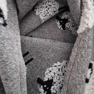 Peça de roupa cinzenta com padrão de ovelhas e interior branco felpudo