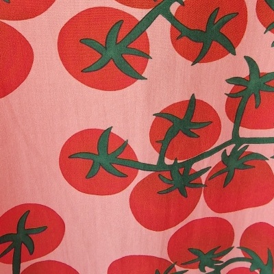 Pano com padrão de tomates vermelhos e ramos verdes sobre fundo cor-de-rosa