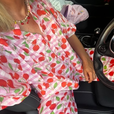 Conjunto de pijama com padrão de cerejas vermelhas em tecido leve num carro