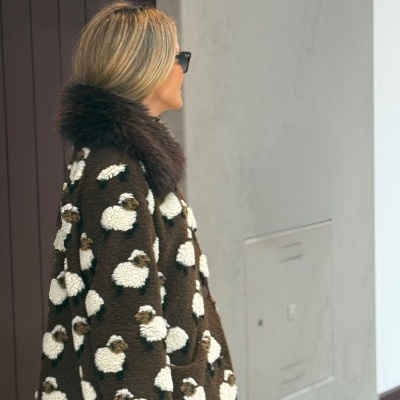 Casaco castanho de pelo com padrão de ovelhas e gola de pelo escuro