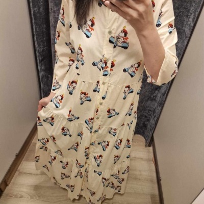 Vestido bege claro com estampa de personagem animado em scooter azul