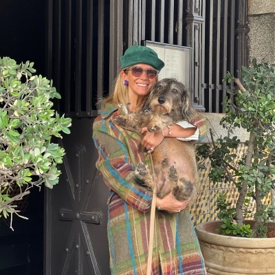 Casaco xadrez colorido com boné verde e cão de pelo comprido