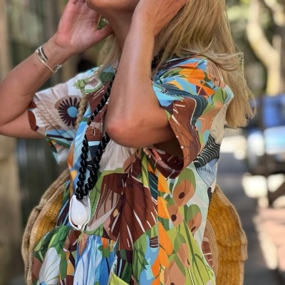 Vestido floral colorido com bolso, colar preto e anel prateado com pedra preta