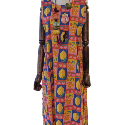 Vestido com padrão colorido de frutas cítricas exibido em manequim com braços de madeira