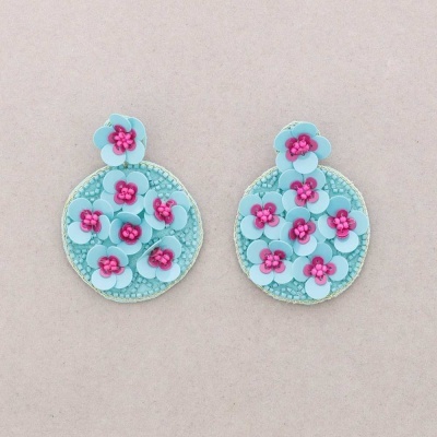 Brincos redondos azuis claros com flores cor de rosa em relevo