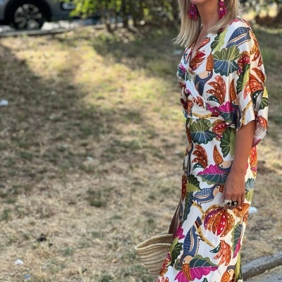 Vestido comprido floral colorido com cinto e decote em V, usado por mulher ao ar livre