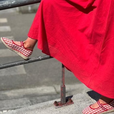 Sapatos espadrilles xadrez vermelho e branco com vestido vermelho ao ar livre