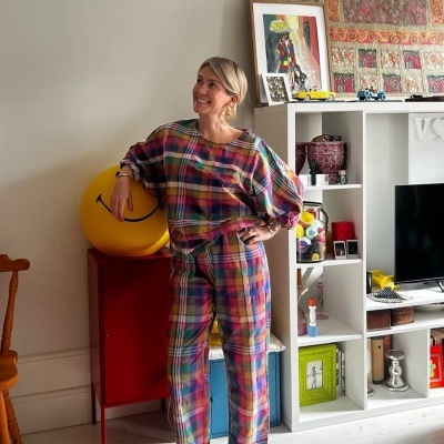 Conjunto de roupa colorido com padrão aos quadrados em mulher num ambiente interior