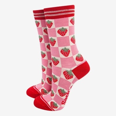 Meias com padrão quadriculado rosa e branco com morangos vermelhos e verdes, detalhes vermelhos nas extremidades.