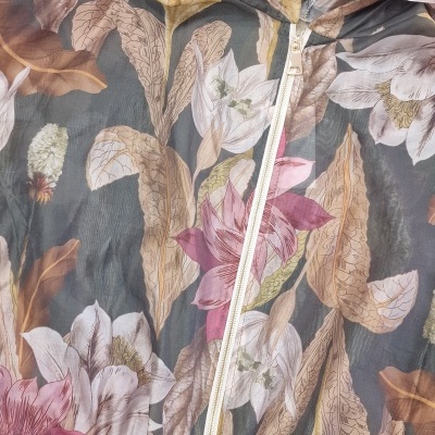 Casaco leve com padrão floral em tons de verde, rosa, amarelo e bege e fecho branco
