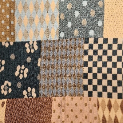 tecido patchwork com padrões variados em tons de azul, bege e castanho