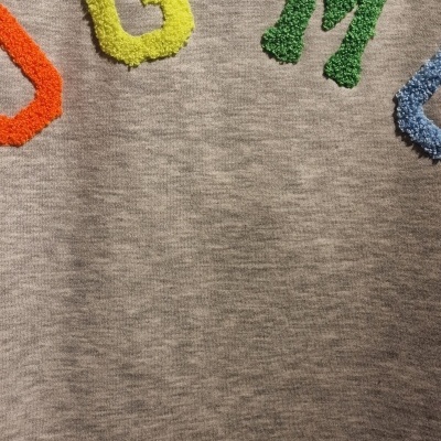 Camisola cinza com letras felpudas coloridas G e M