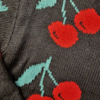 Camisola preta de malha com padrão de cerejas vermelhas e folhas verdes