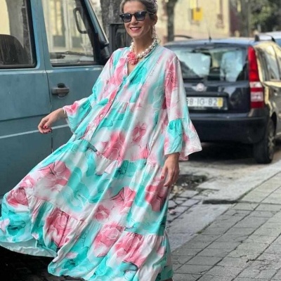 Mulher com vestido colorido fluído numa rua da cidade
