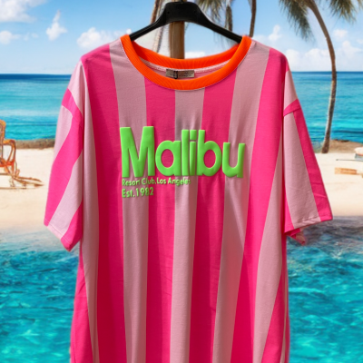 T-shirt às riscas rosa e rosa claro com texto verde Malibu, pendurada numa praia com palmeiras