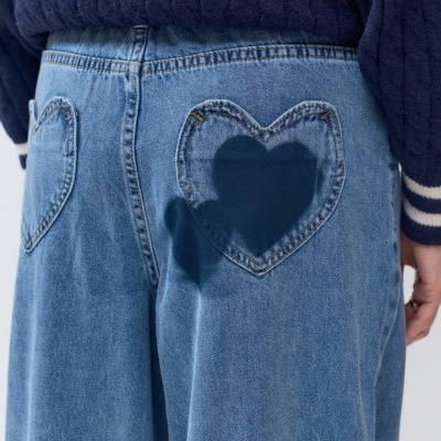 Calças de ganga azuis claras com bolsos traseiros em forma de coração e camisola azul escura