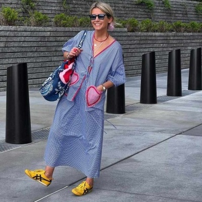 Mulher com túnica azul riscada com bolsos em formato de coração e ténis amarelos