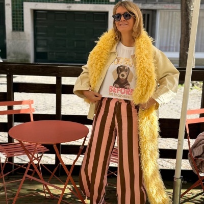 Mulher com roupa casual colorida em esplanada exterior com mesa e cadeiras