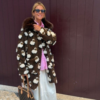 Mulher com casaco peludo castanho com padrão de ovelhas e bolsa Louis Vuitton