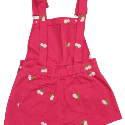 Jardineira curta infantil rosa com estampado de cerejas e bolsos nas costas